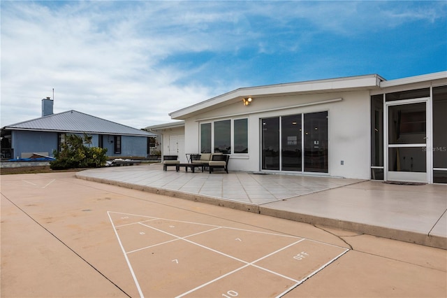 view of property's community featuring shuffleboard and a patio