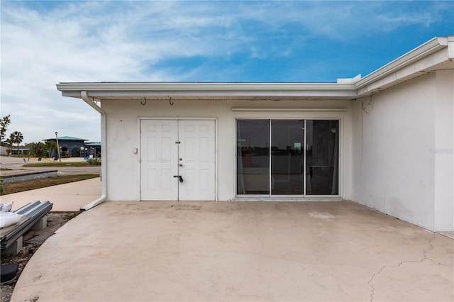 doorway to property with a patio and stucco siding