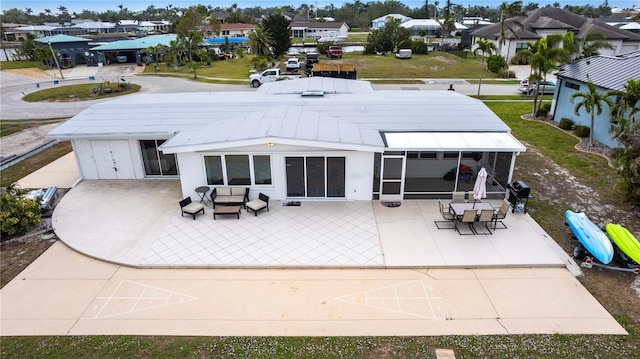 rear view of house with a residential view, a patio, and a sunroom