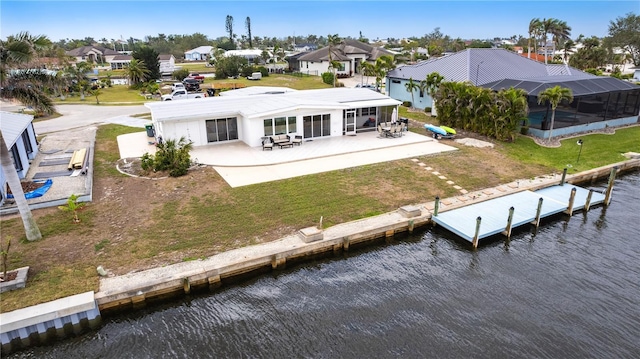 rear view of house featuring a residential view, a yard, and a water view