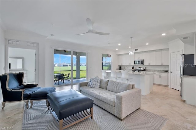 living room with a ceiling fan, recessed lighting, and visible vents