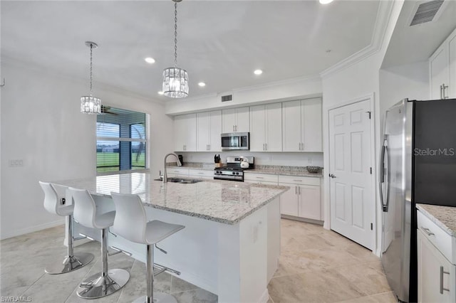 kitchen featuring appliances with stainless steel finishes, white cabinetry, crown molding, and a sink