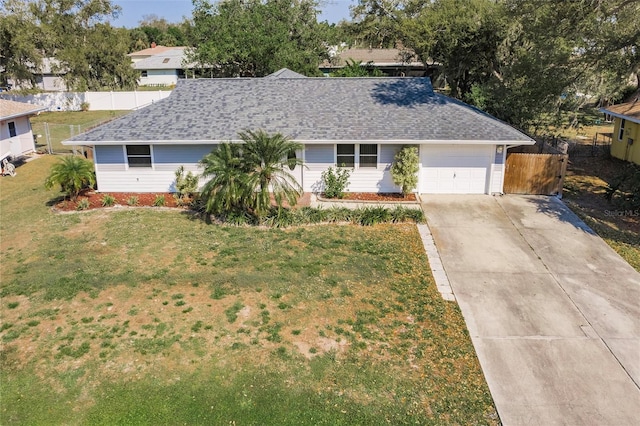 single story home featuring fence, a shingled roof, concrete driveway, a front lawn, and a garage