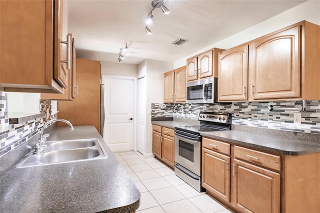 kitchen with visible vents, a sink, dark countertops, appliances with stainless steel finishes, and light tile patterned floors