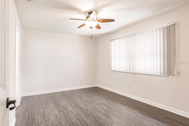 spare room with ceiling fan, a textured ceiling, dark wood-type flooring, and baseboards