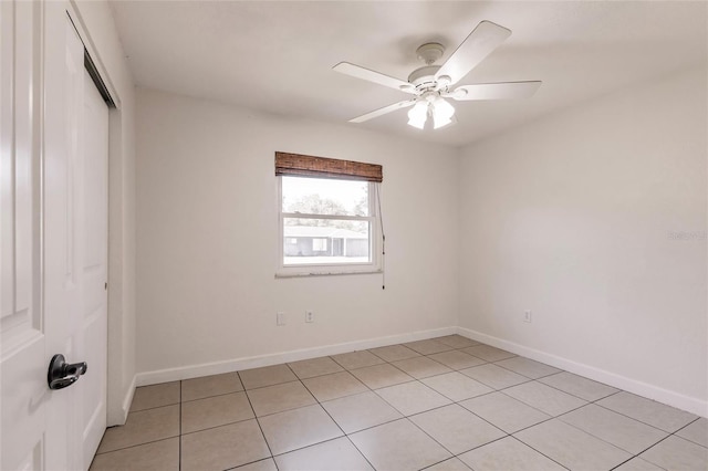 spare room with light tile patterned flooring, baseboards, and ceiling fan