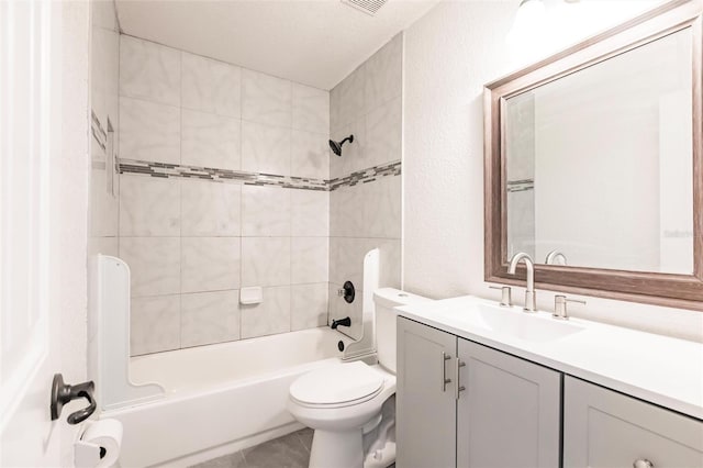 full bathroom featuring vanity, washtub / shower combination, tile patterned flooring, toilet, and a textured wall