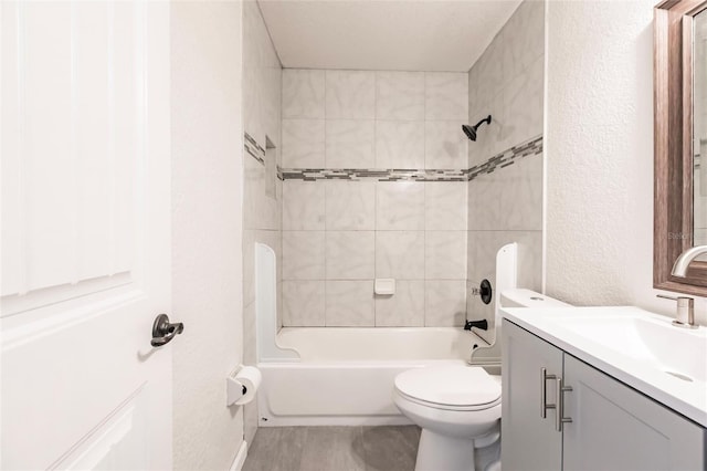 full bathroom with toilet, shower / washtub combination, vanity, and a textured wall