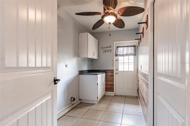 laundry area featuring light tile patterned floors, cabinet space, and a ceiling fan