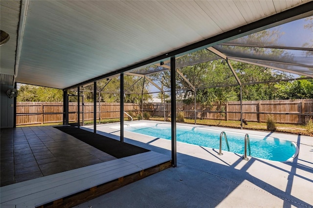 view of swimming pool featuring glass enclosure, a patio area, a fenced in pool, and a fenced backyard