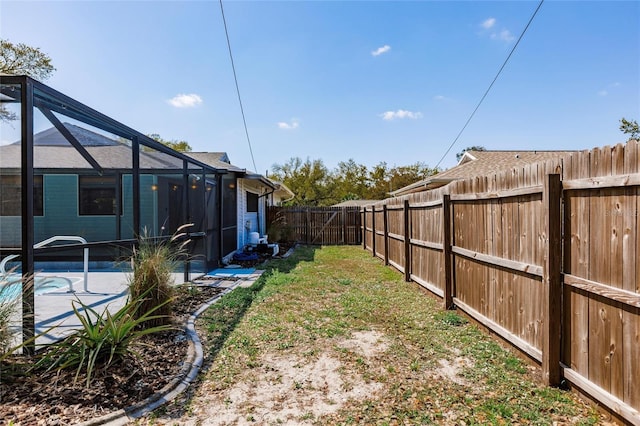 view of yard with a lanai, a patio area, a fenced in pool, and a fenced backyard