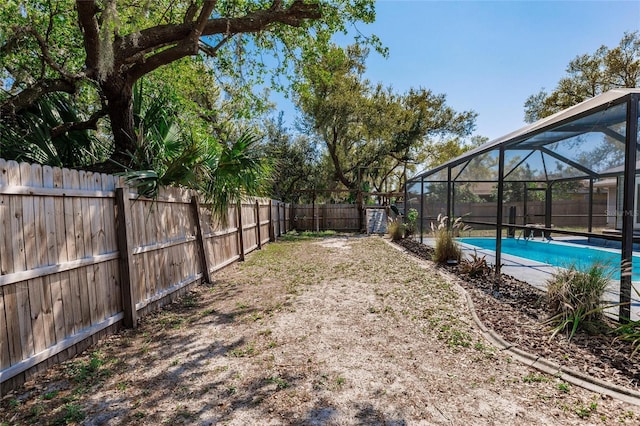 view of yard featuring a lanai, a fenced backyard, and a fenced in pool