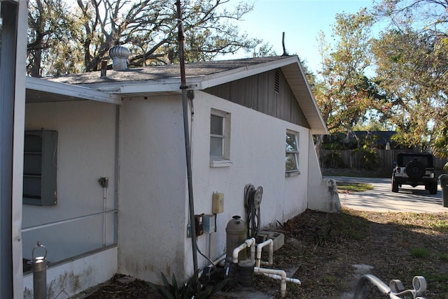 view of home's exterior with a patio, fence, and stucco siding