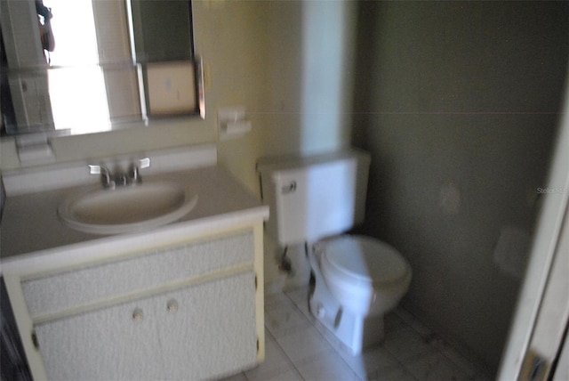 bathroom featuring toilet, tile patterned flooring, and vanity