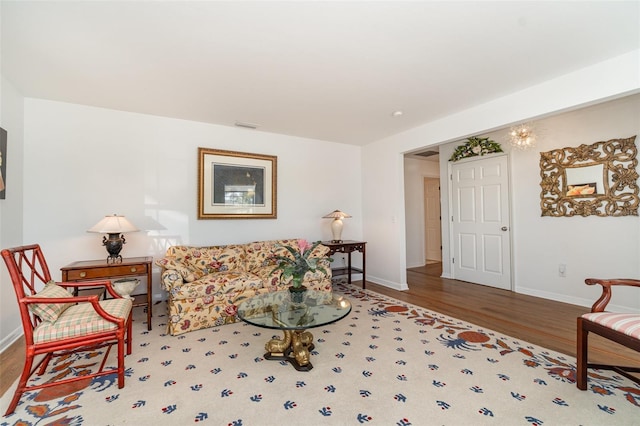 living area featuring visible vents, baseboards, and wood finished floors