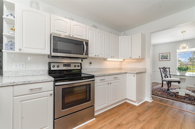 kitchen with open shelves, light wood-style flooring, stainless steel appliances, decorative backsplash, and white cabinets