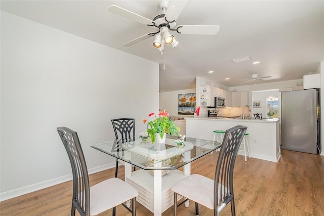 dining area featuring recessed lighting, light wood-style flooring, a ceiling fan, and baseboards