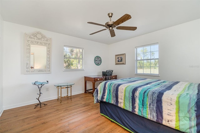 bedroom featuring a ceiling fan, light wood-type flooring, and baseboards