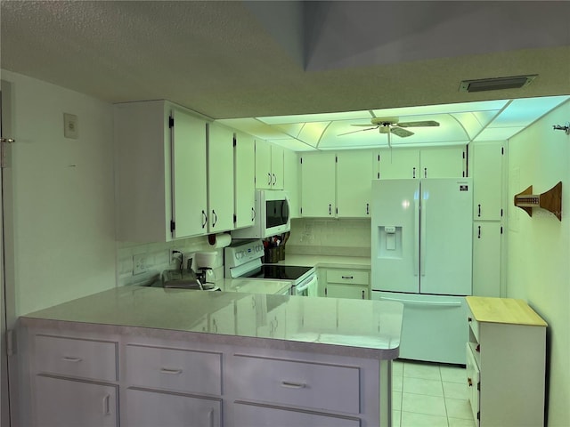 kitchen with visible vents, ceiling fan, light countertops, a peninsula, and white appliances