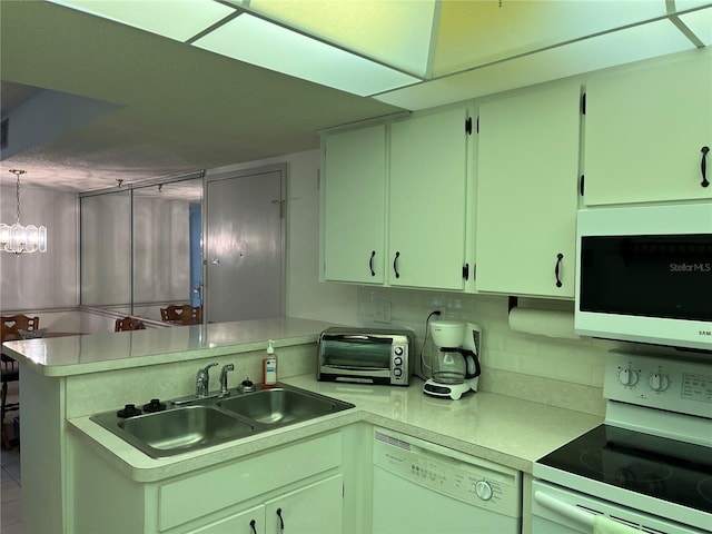 kitchen with white appliances, a peninsula, a toaster, a sink, and light countertops