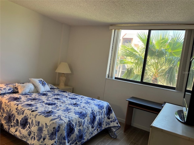 bedroom featuring a textured ceiling and wood tiled floor