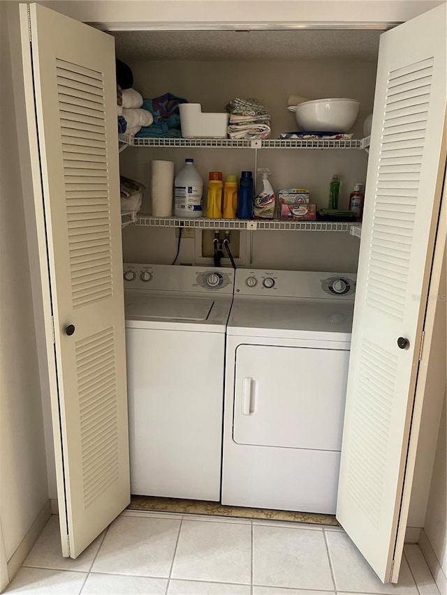 laundry area featuring washer and dryer, laundry area, and light tile patterned floors