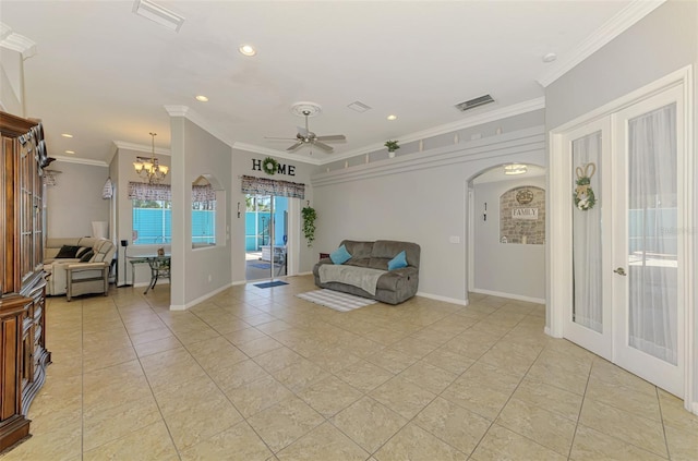 living area featuring visible vents, arched walkways, french doors, and ornamental molding