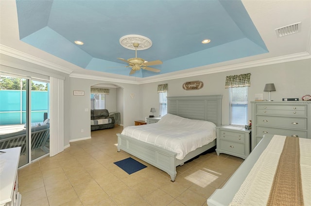 bedroom with arched walkways, visible vents, a tray ceiling, and access to outside