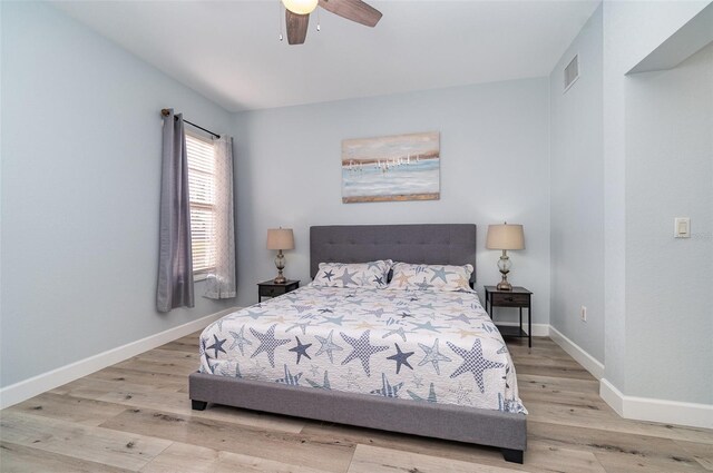 bedroom featuring a ceiling fan, wood finished floors, visible vents, and baseboards