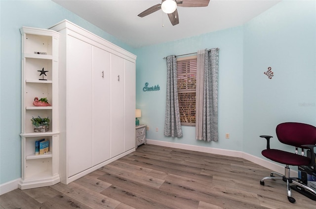 office area with a ceiling fan, baseboards, and light wood finished floors