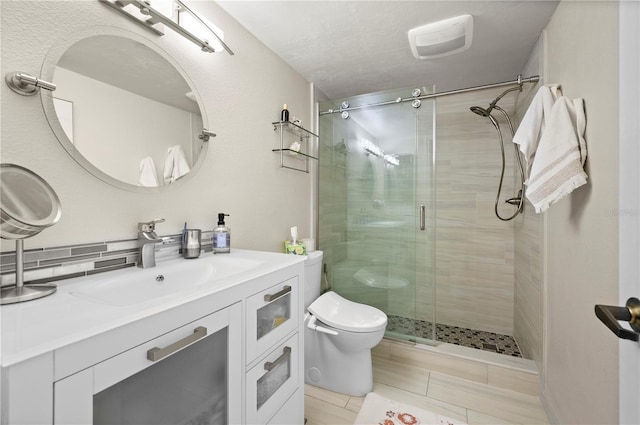 full bath with vanity, toilet, and a stall shower