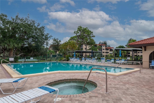 pool featuring a patio, fence, and a hot tub