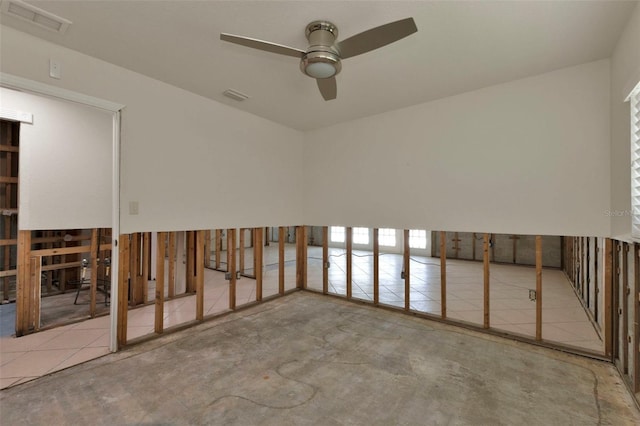 spare room with ceiling fan, visible vents, and concrete flooring