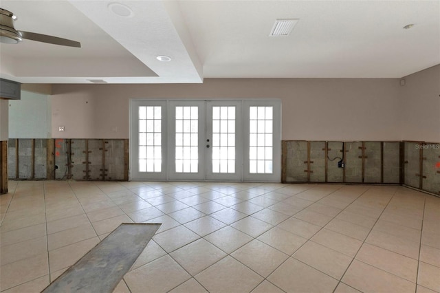 unfurnished room featuring light tile patterned floors, plenty of natural light, a raised ceiling, and visible vents