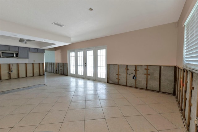 empty room with visible vents, french doors, and light tile patterned flooring