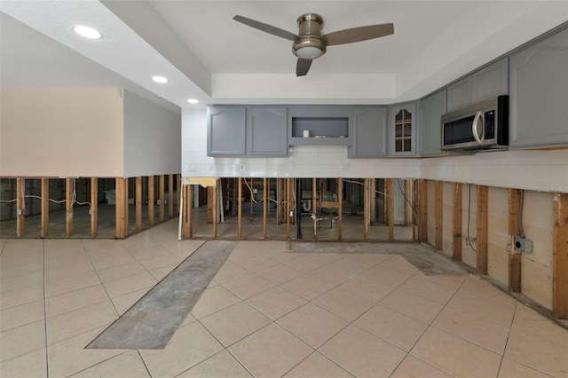 kitchen featuring light tile patterned floors, ceiling fan, stainless steel microwave, gray cabinets, and recessed lighting