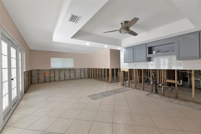 interior space with light tile patterned floors, ceiling fan, recessed lighting, visible vents, and a tray ceiling