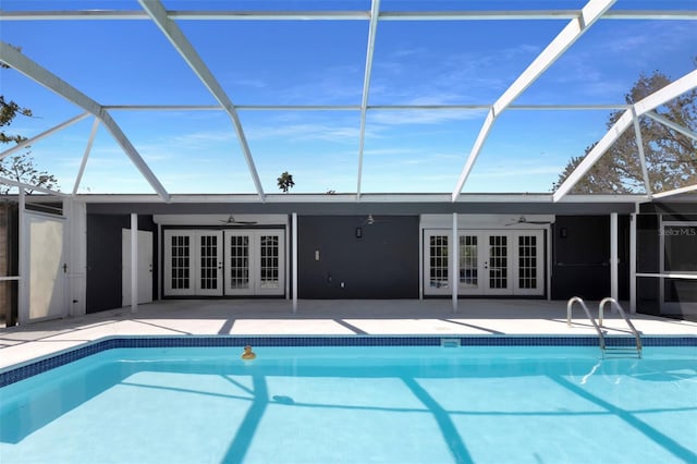 outdoor pool with a patio area, glass enclosure, and french doors