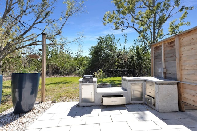 view of patio featuring an outdoor kitchen and fence