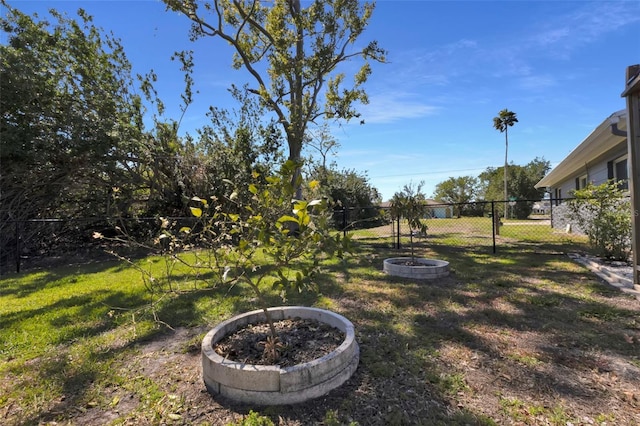 view of yard with fence and a fire pit