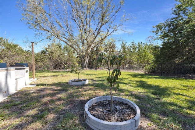 view of yard featuring a fenced backyard and a fire pit