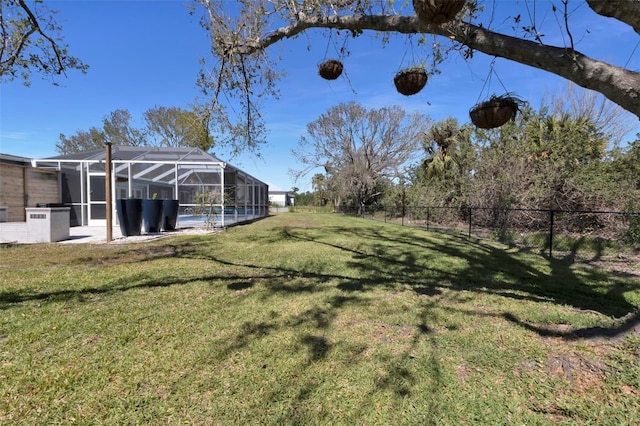 view of yard with a fenced in pool, glass enclosure, and fence