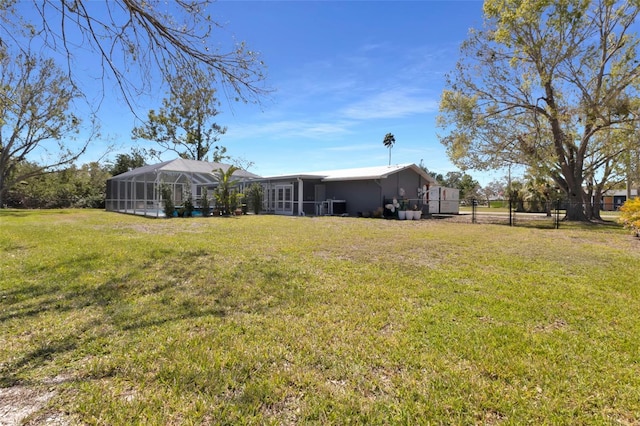 view of yard featuring glass enclosure and fence