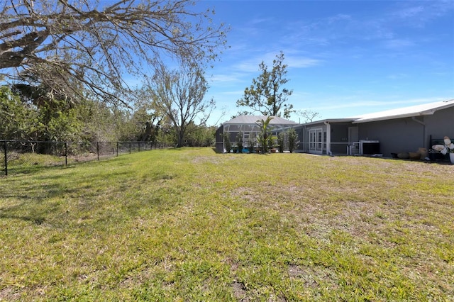 view of yard with glass enclosure, fence, and cooling unit