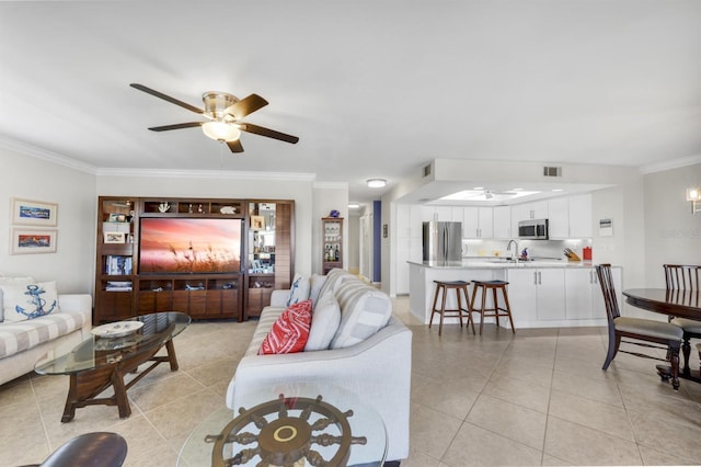 living room with light tile patterned floors, ornamental molding, visible vents, and a ceiling fan