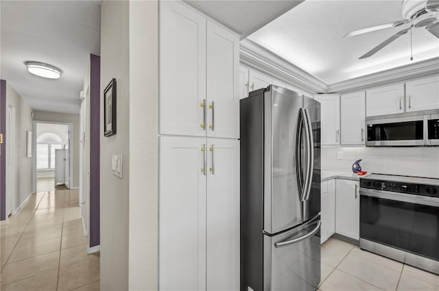 kitchen featuring light tile patterned floors, white cabinetry, stainless steel appliances, and a ceiling fan