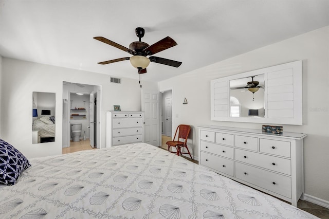 bedroom with ceiling fan, visible vents, baseboards, and ensuite bathroom