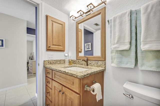 bathroom with baseboards, visible vents, toilet, tile patterned floors, and vanity