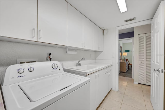 laundry room featuring washer / dryer, cabinet space, light tile patterned floors, visible vents, and a sink