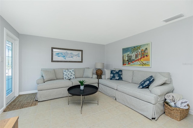 living area featuring baseboards and visible vents